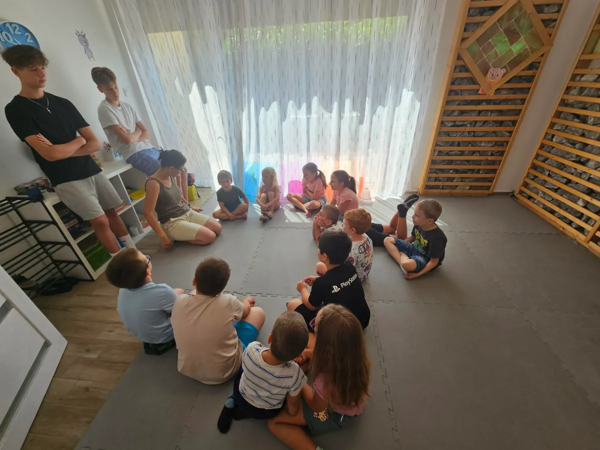 Meseidő — gyerekek körben ülnek és figyelnek